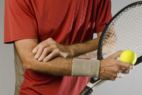tennis player massaging elbow