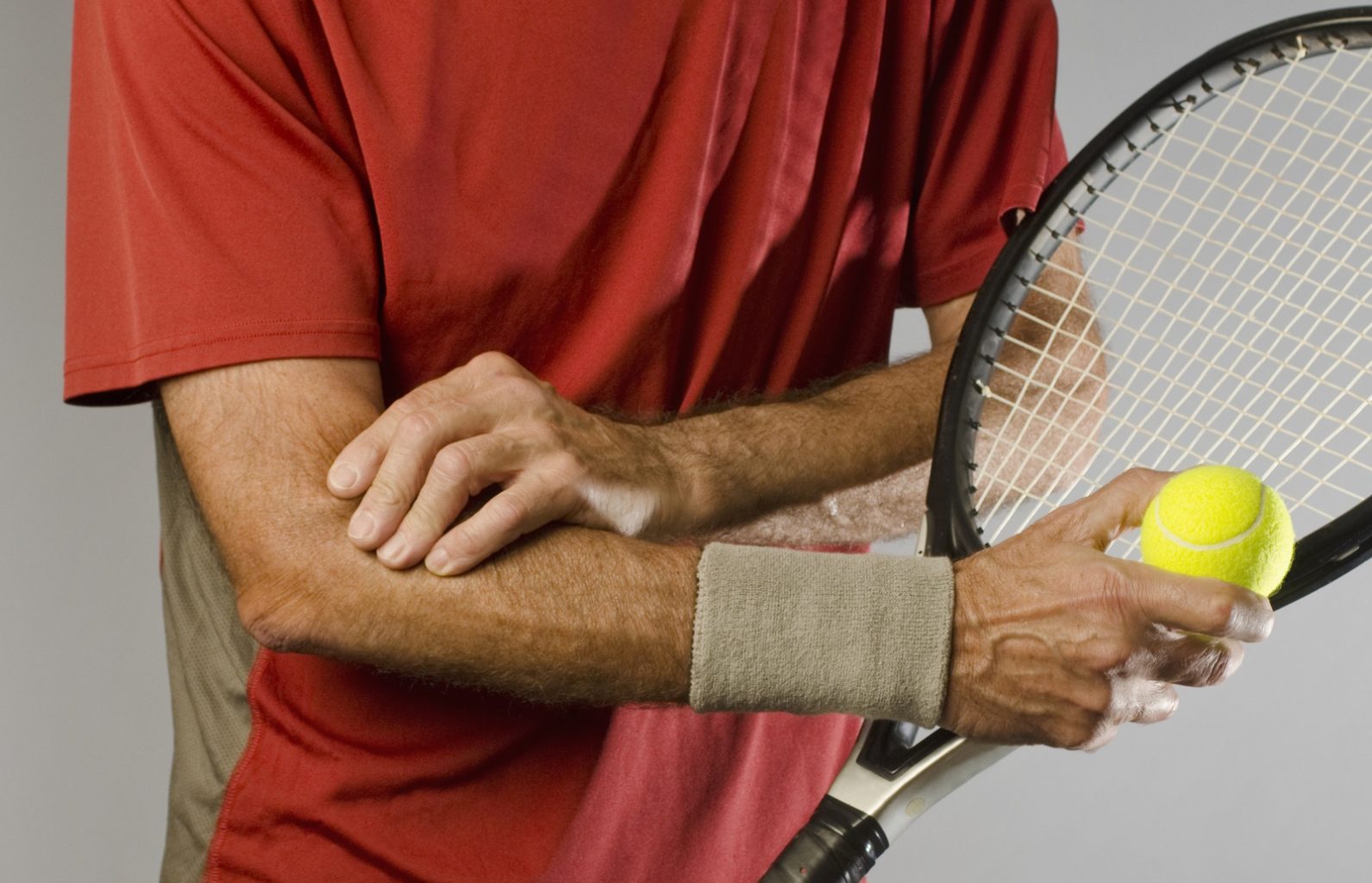 tennis player massaging elbow